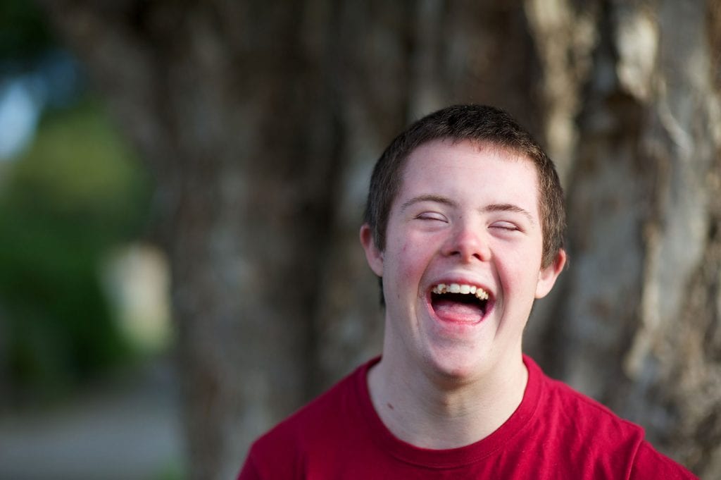 Teenage boy with down syndrome laughing