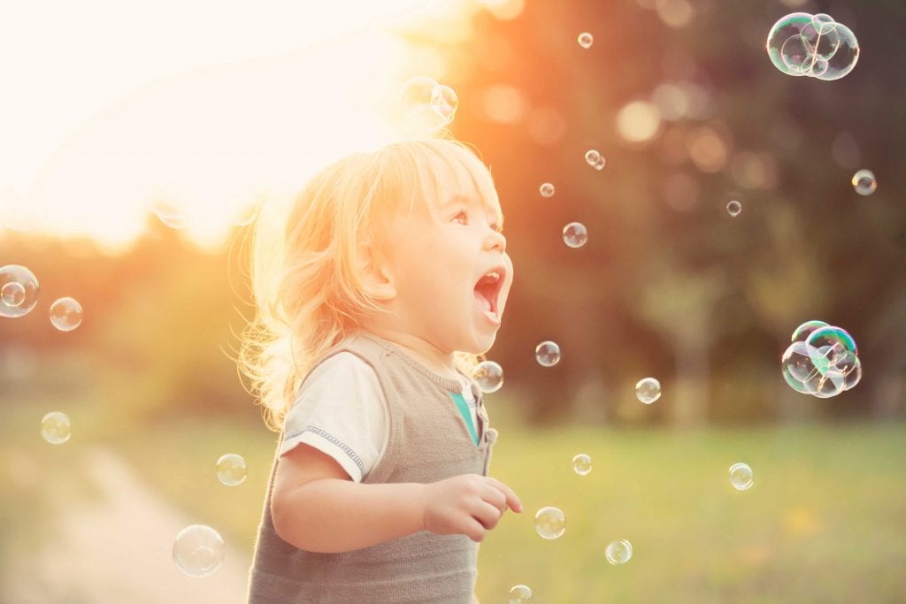 young girl chasing bubbles