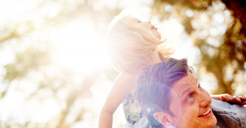 young girl being piggy backed by her father