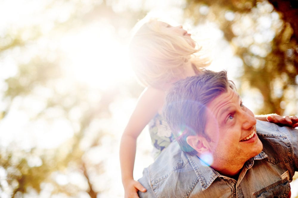 young girl being piggy backed by her father